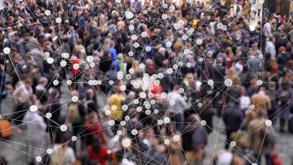 Visualization of coronavirus multiplying with a background of people at a train station concourse.