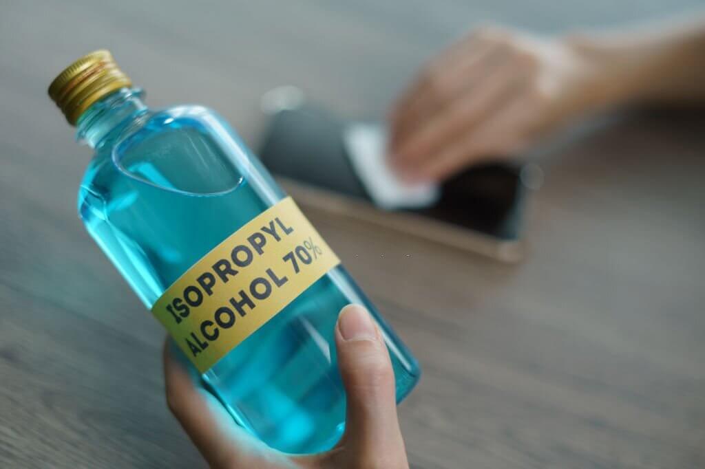 Hand with Isopropyl alcohol for clean mobile phone, corona virus or Covid-19 protection.