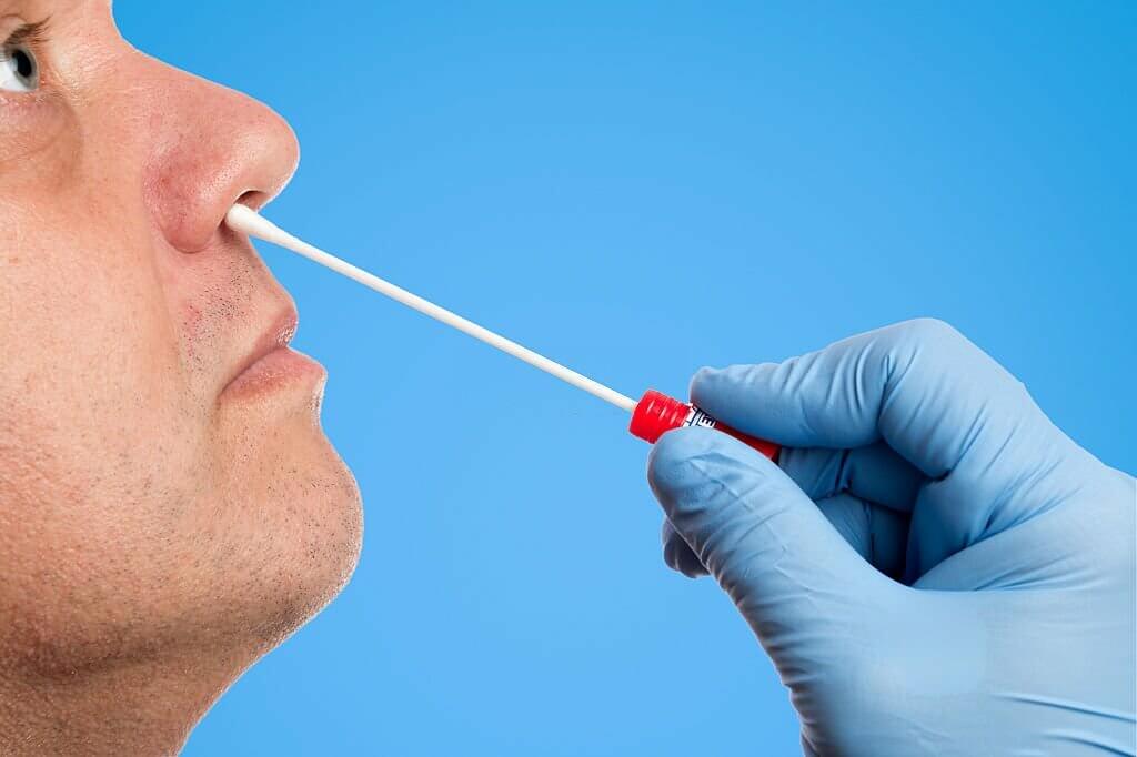 Doctor makes with a rayon swab a nasal swab test