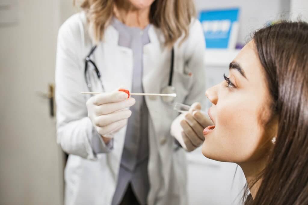 a doctor doing a oral swab test for a woman