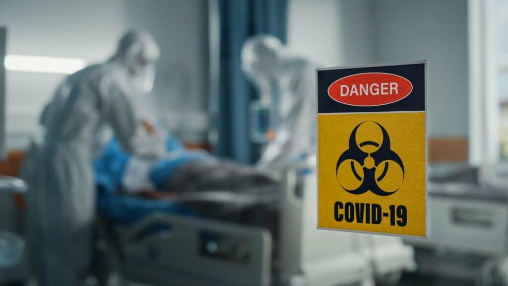 Hospital Coronavirus Emergency Department Ward: Doctors wearing Coveralls, Face Masks Treat, Cure and Save Lives of Patients. Focus on Biohazard Sign on Door