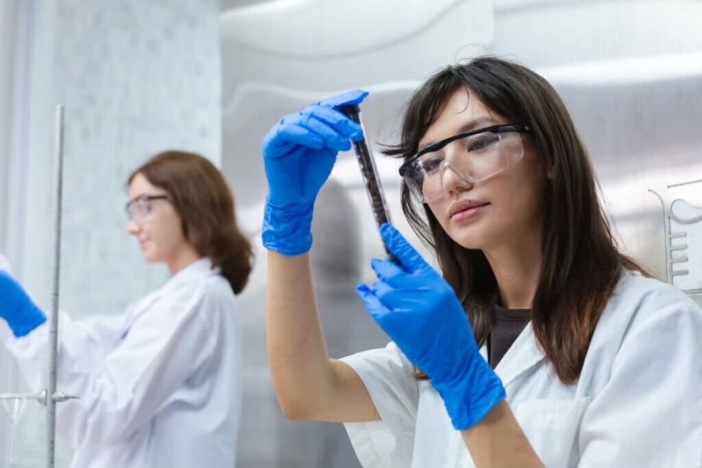 Young women scientist are working research and test environmental samples with test tubes in laboratory