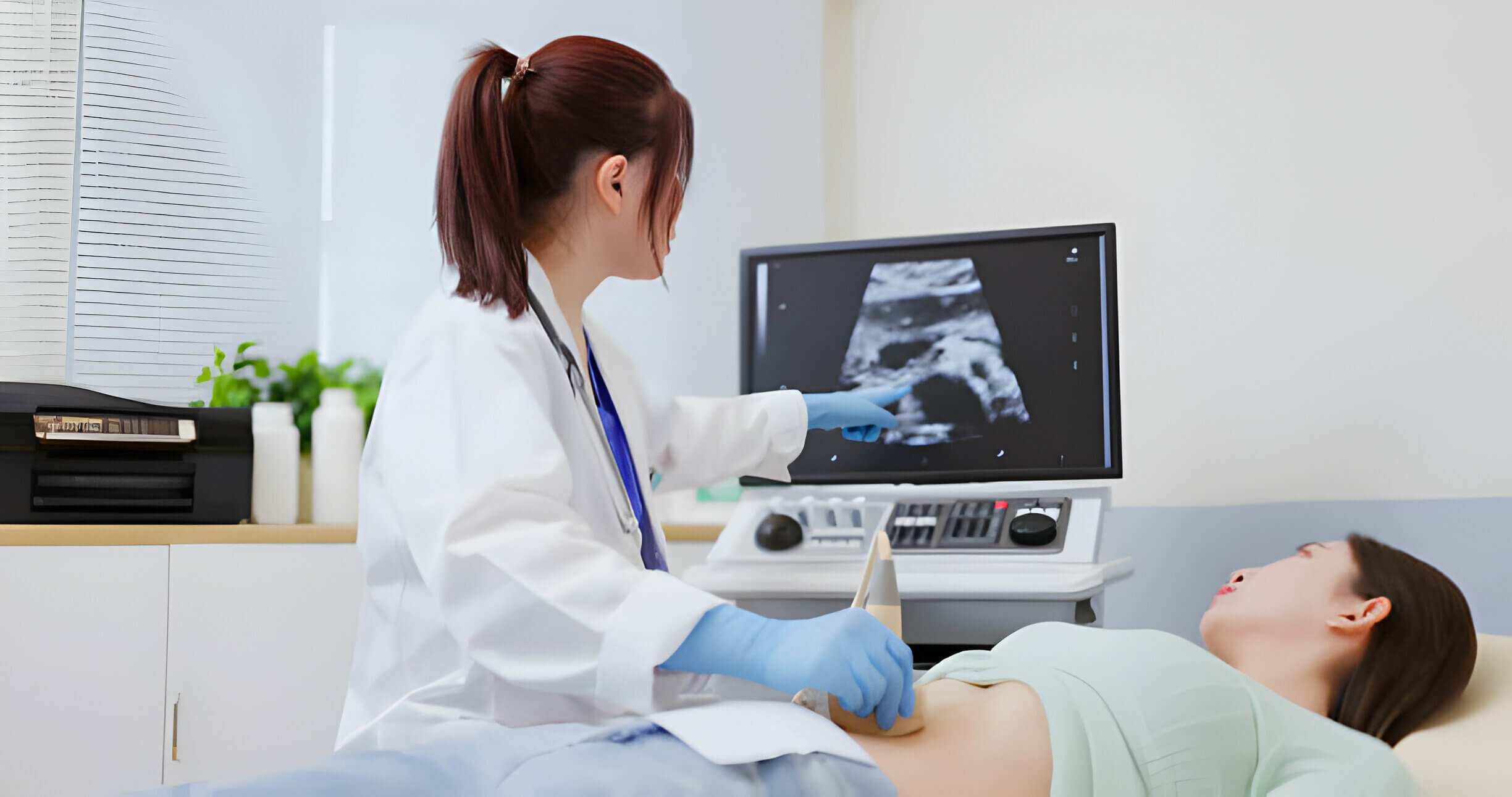Asian doctor using ultrasound scanner performing examination of belly for her patient