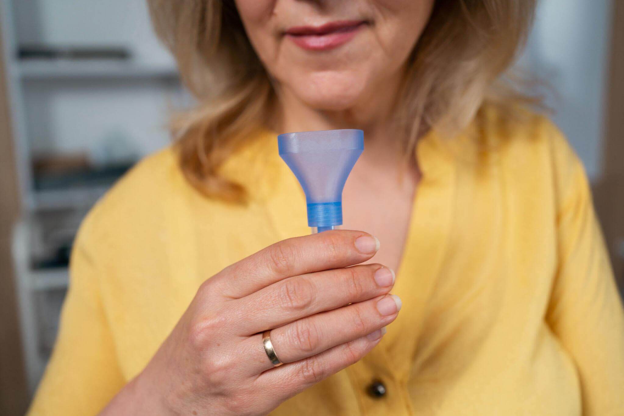 Close-up of an unrecognizable female patient holding a spit collector