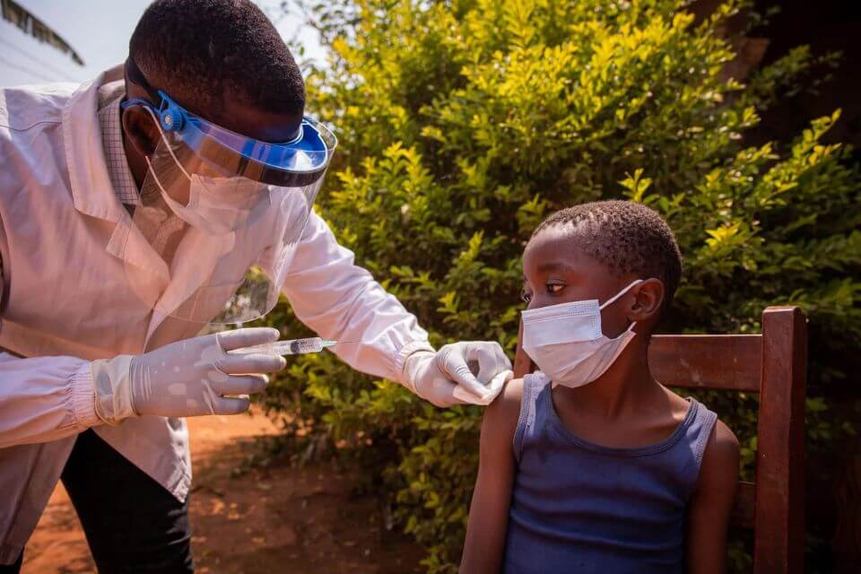 A doctor in africa vaccinates a child