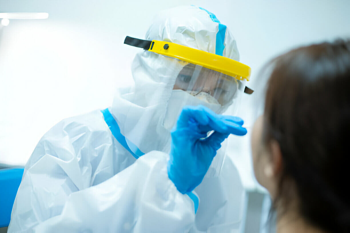 Medical worker taking a swab for corona virus sample from potentially infected woman with the isolation gown or protective suits and surgical face masks