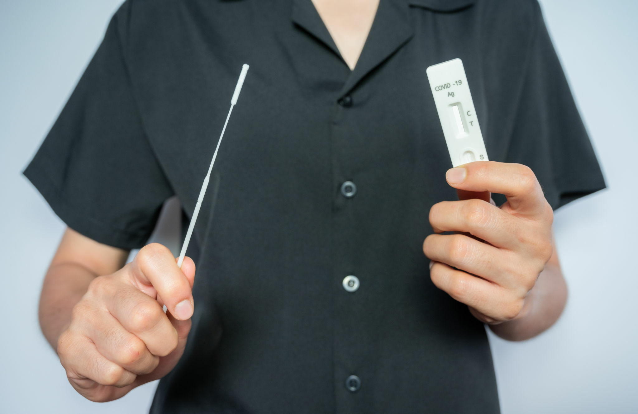 Woman holding a disposable sterile flocked swab with a test pad